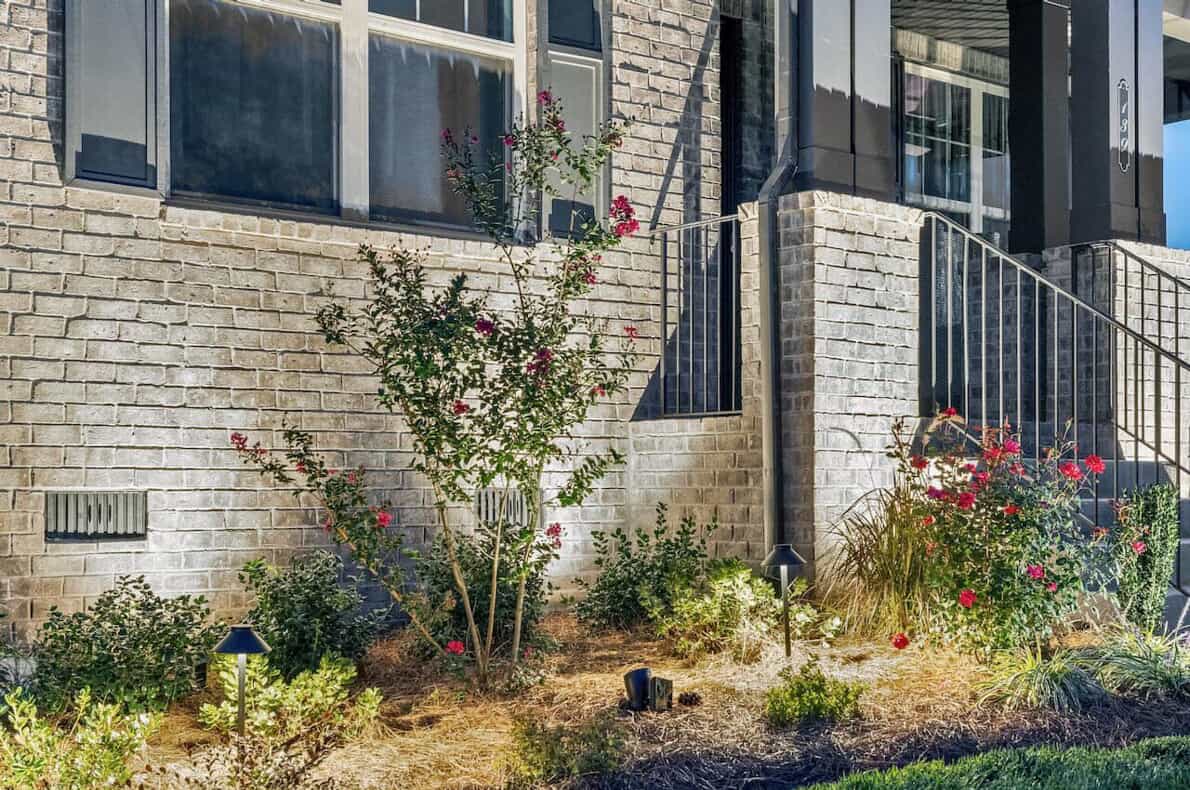 A lovely brick residence with a manicured yard and flourishing flower beds